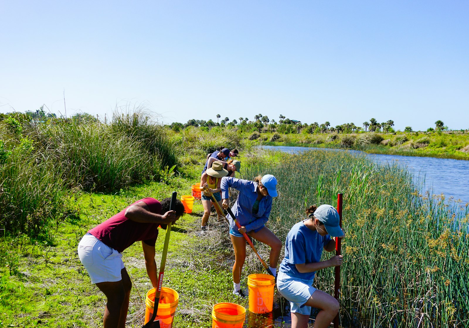 Un groupe de bénévoles au travail le long d’un cours d’eau